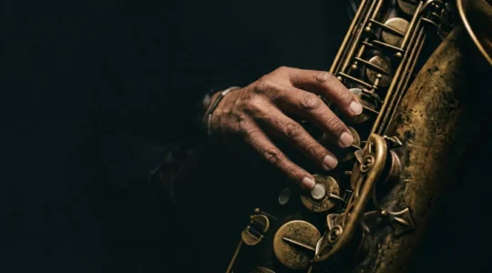 Jazz musician's hands creating expressive bebop lines on instrument with natural dramatic lighting