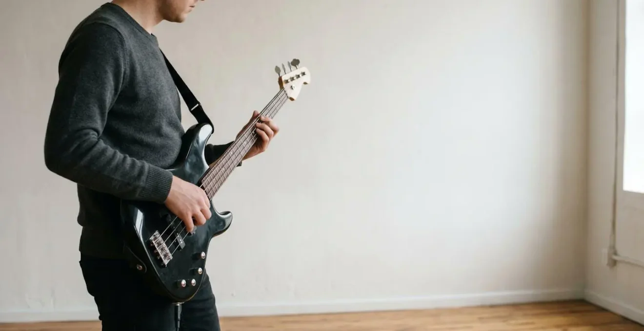 Wide-angle environmental shot showing proper bass guitar playing posture with straight wrist alignment and optimal strap height