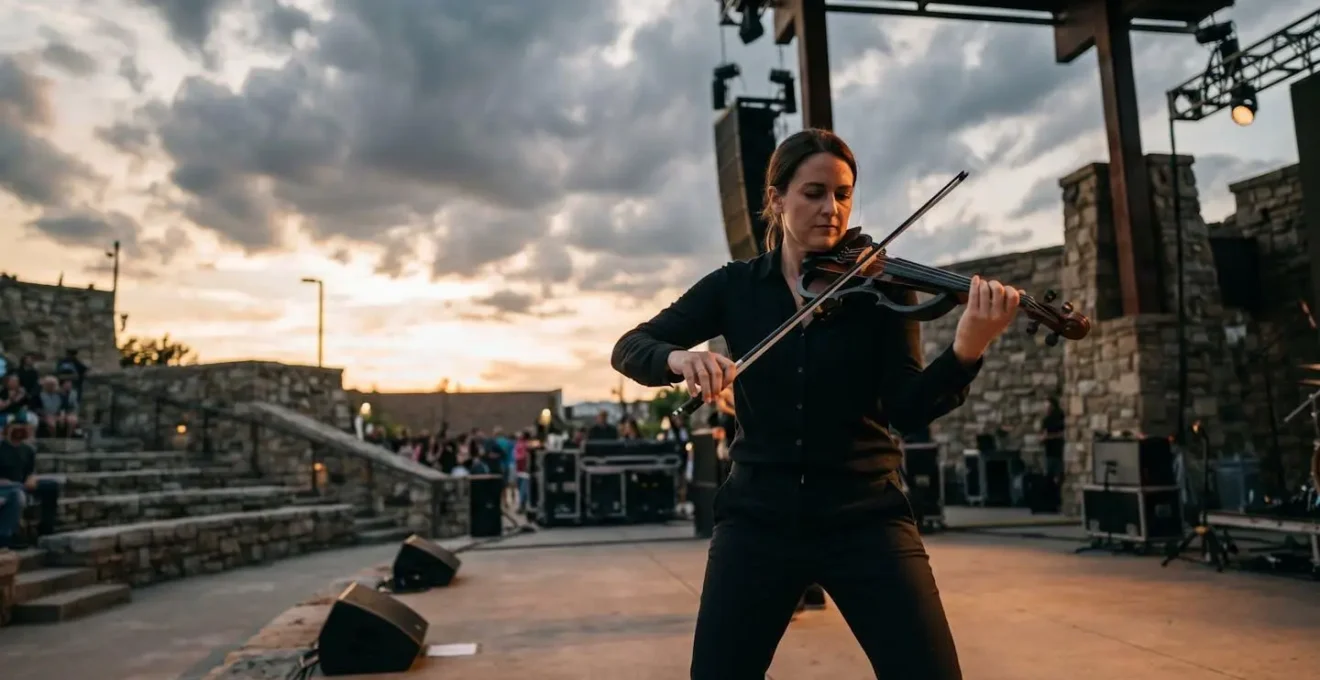 Wide angle environmental shot showing musician with carbon fiber bow in challenging outdoor performance venue with dramatic weather conditions