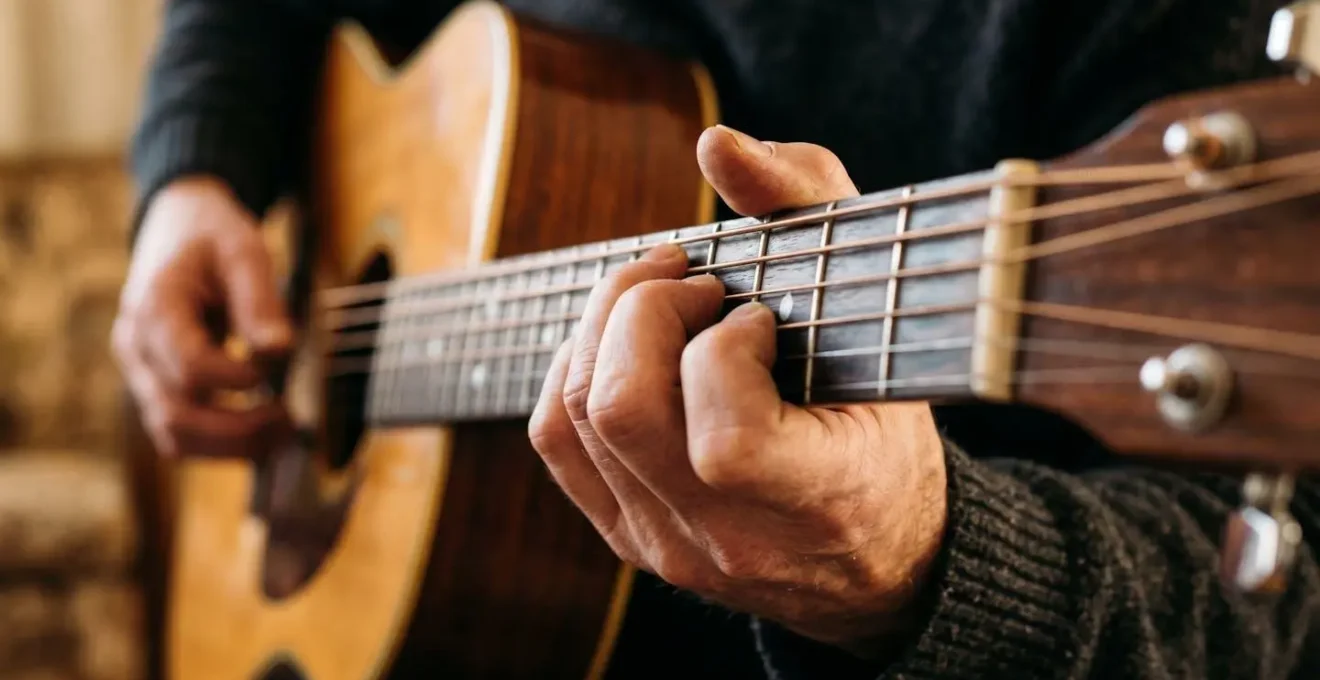 Detailed close-up of guitarist's fingers executing precise chord formation on fretboard