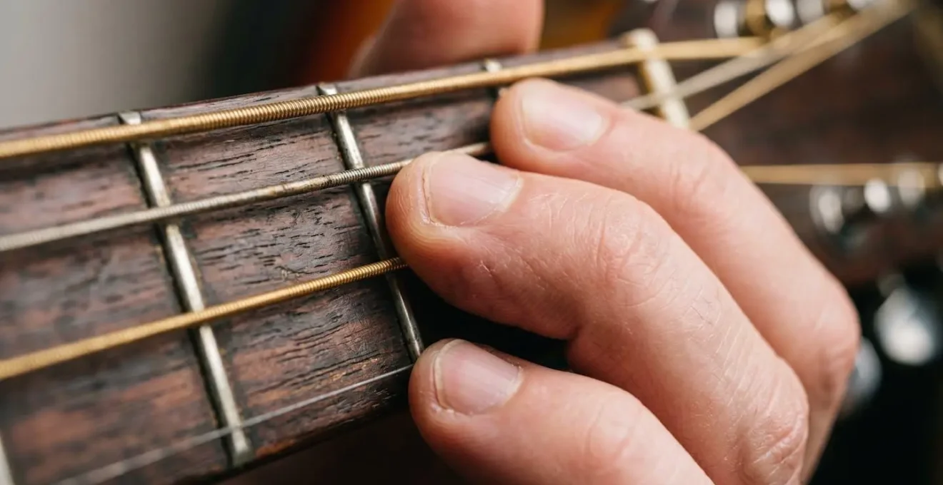 Extreme close-up of musician's fingers on instrument showing precise hand positioning and tactile engagement