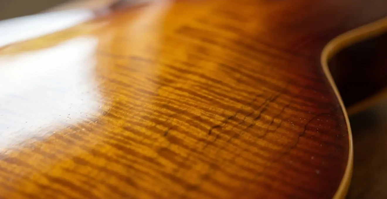 Close-up macro detail of guitar finish surface showing the vulnerable nitrocellulose lacquer texture without any contact materials