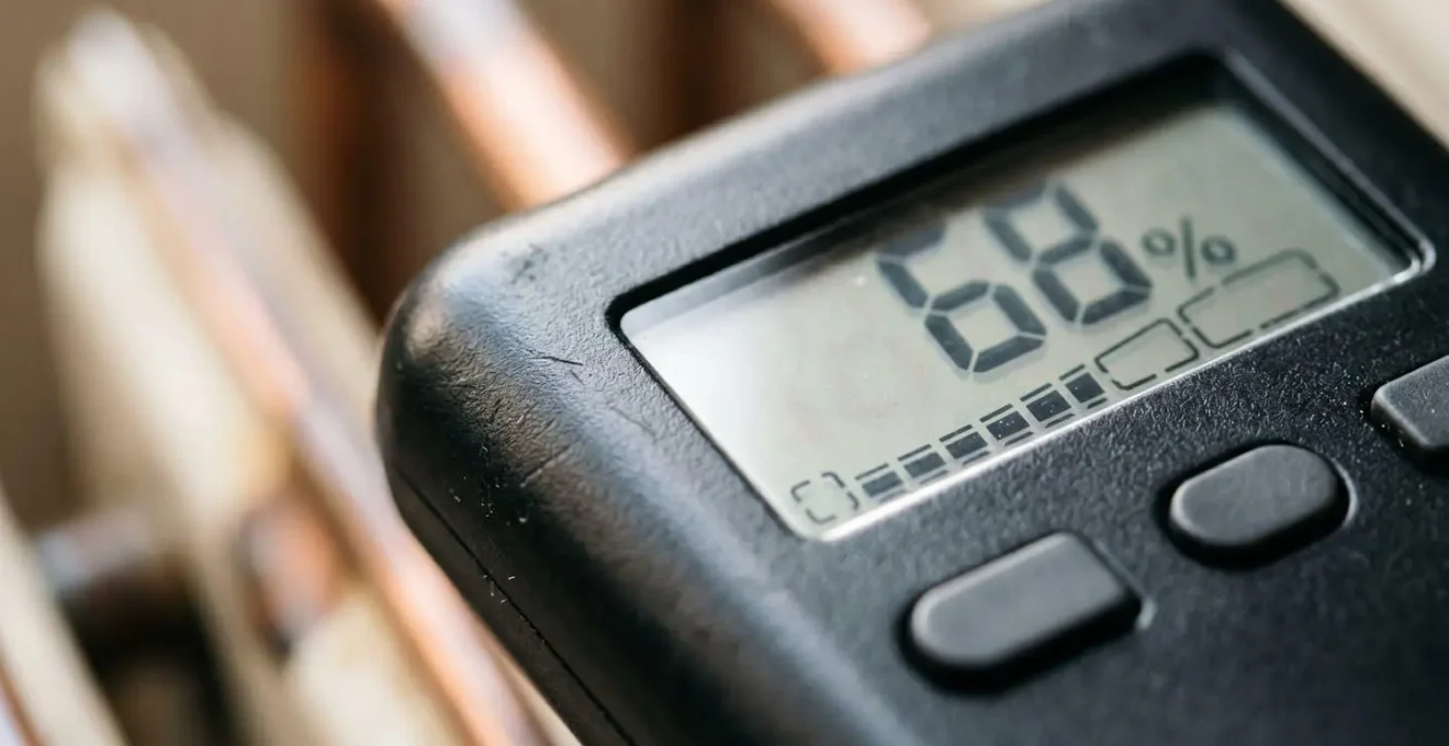 Hygrometer device measuring humidity levels near a radiator, showing environmental monitoring