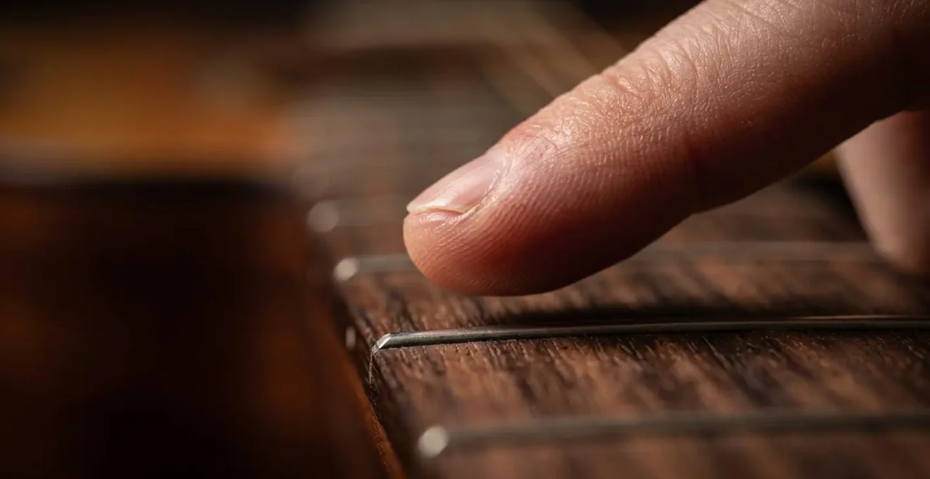 Extreme close-up of fingers suspended above an instrument surface, capturing a moment of controlled restraint