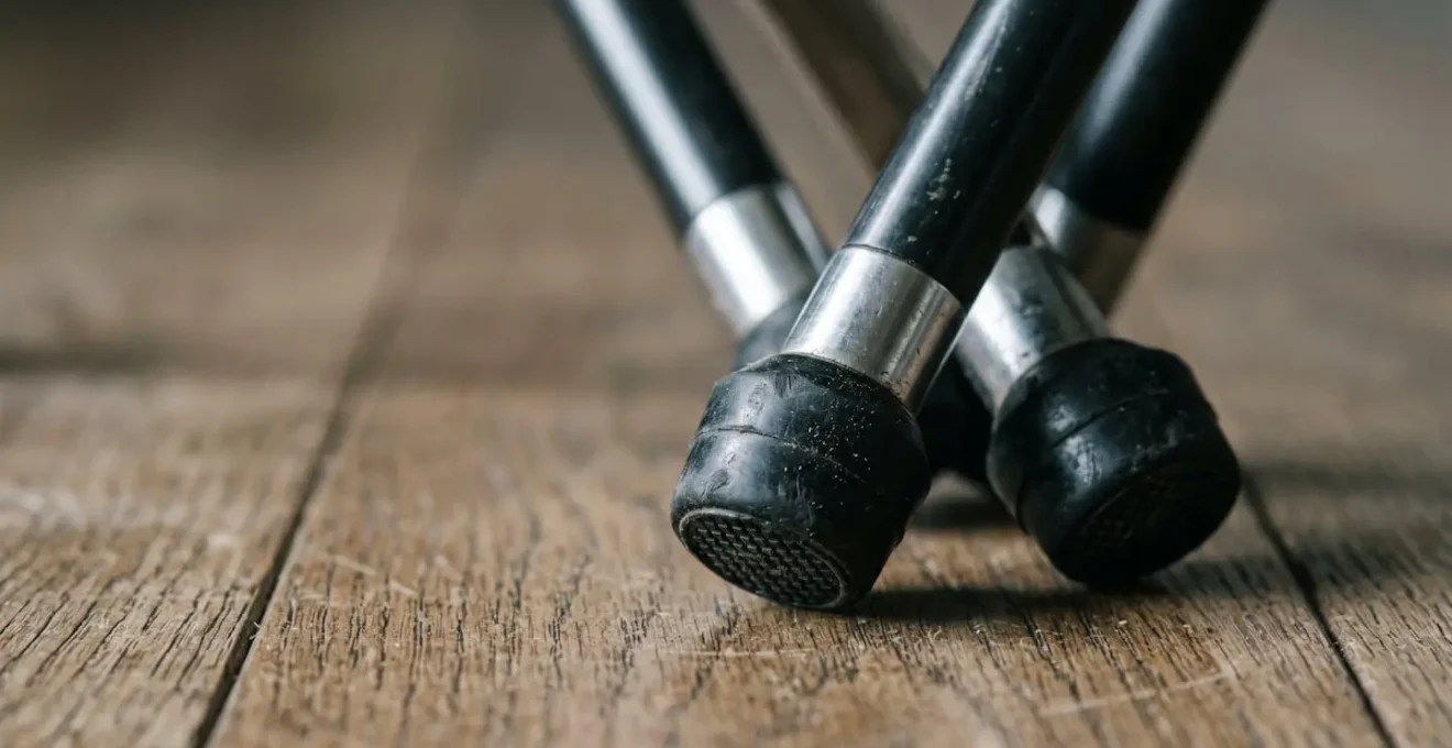 Close-up detail showing the narrow base and high center of gravity of a tripod guitar stand